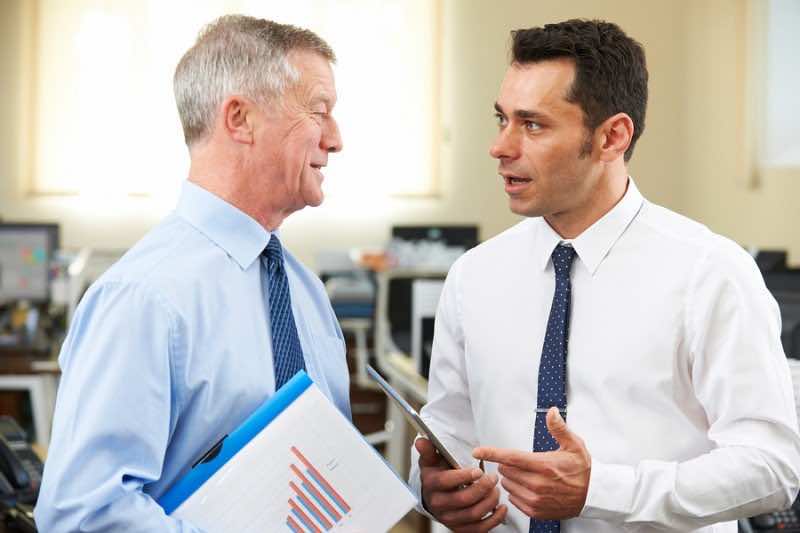 Businessman Having Discussion With Senior Mentor In Office