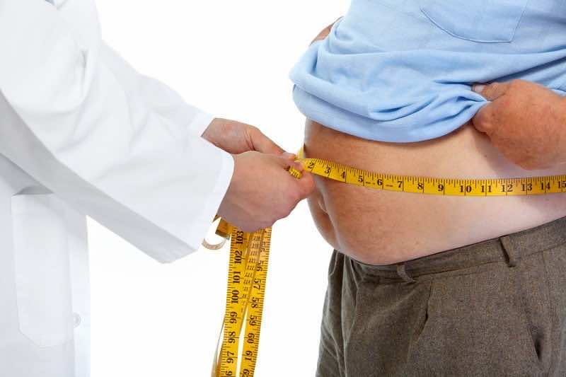 Doctor measuring obese man waist body fat. Obesity and weight lo