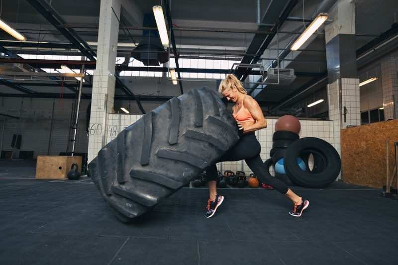 Woman Flipping A Huge Tire At Gym