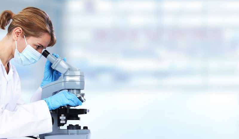 Doctor woman with microscope in laboratory. Scientific research.