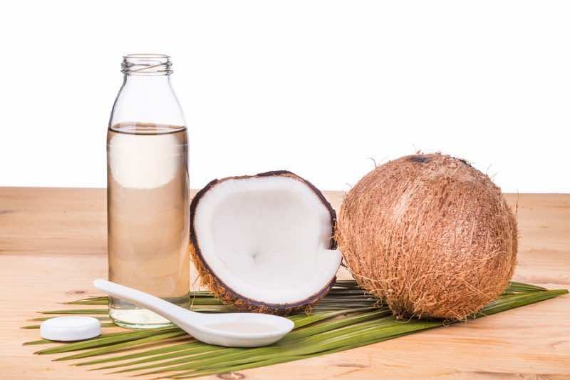 Cold Pressed Extra Virgin Coconut Oil In Bottles With Coconuts