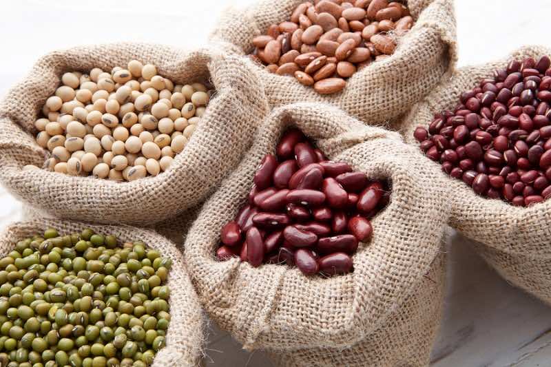 Assortment Of Beans And Lentils In Hemp Sack On Wooden Backgroun