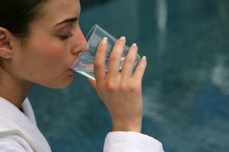 Portrait of a young woman drinking a glass of water