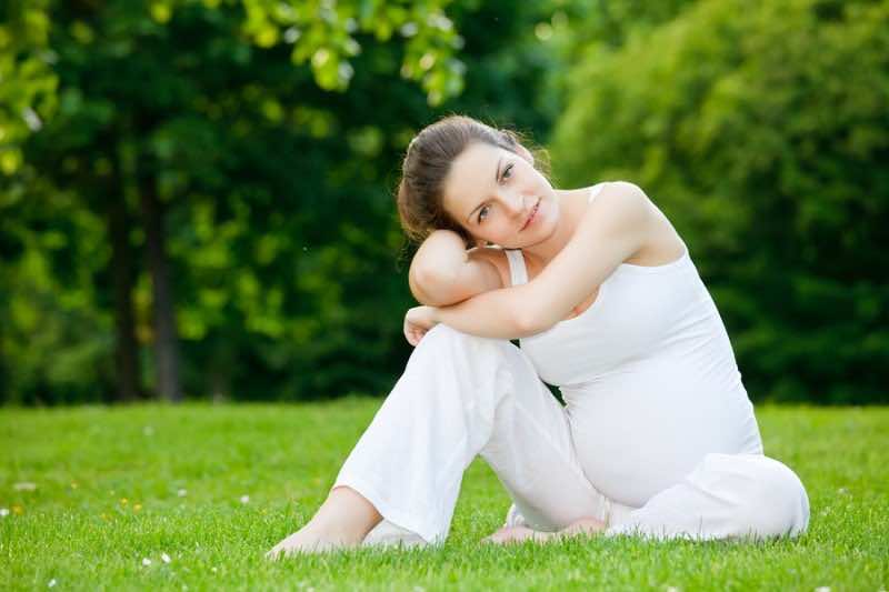 Beautiful pregnant woman relaxing in the park